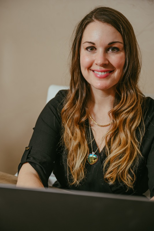 Ashley Granby seated with a laptop.