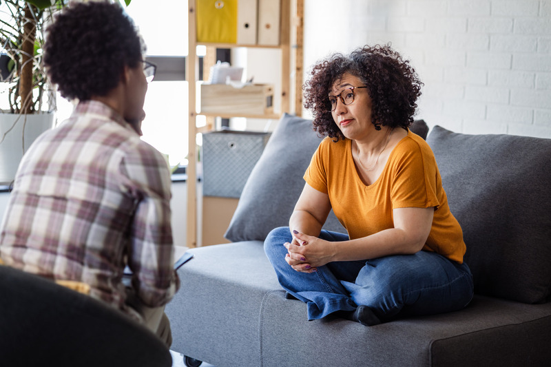 A therapist and client speaking in a calm office setting.